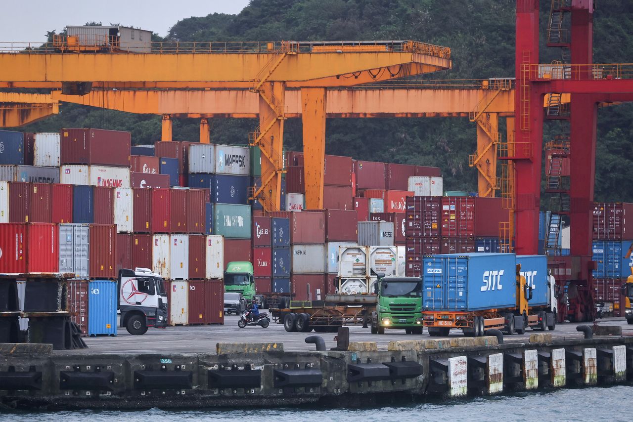 FILE PHOTO: Cargo trucks work inside a container yard in Keelung, Taiwan, January 7, 2022. REUTERS/Ann Wang