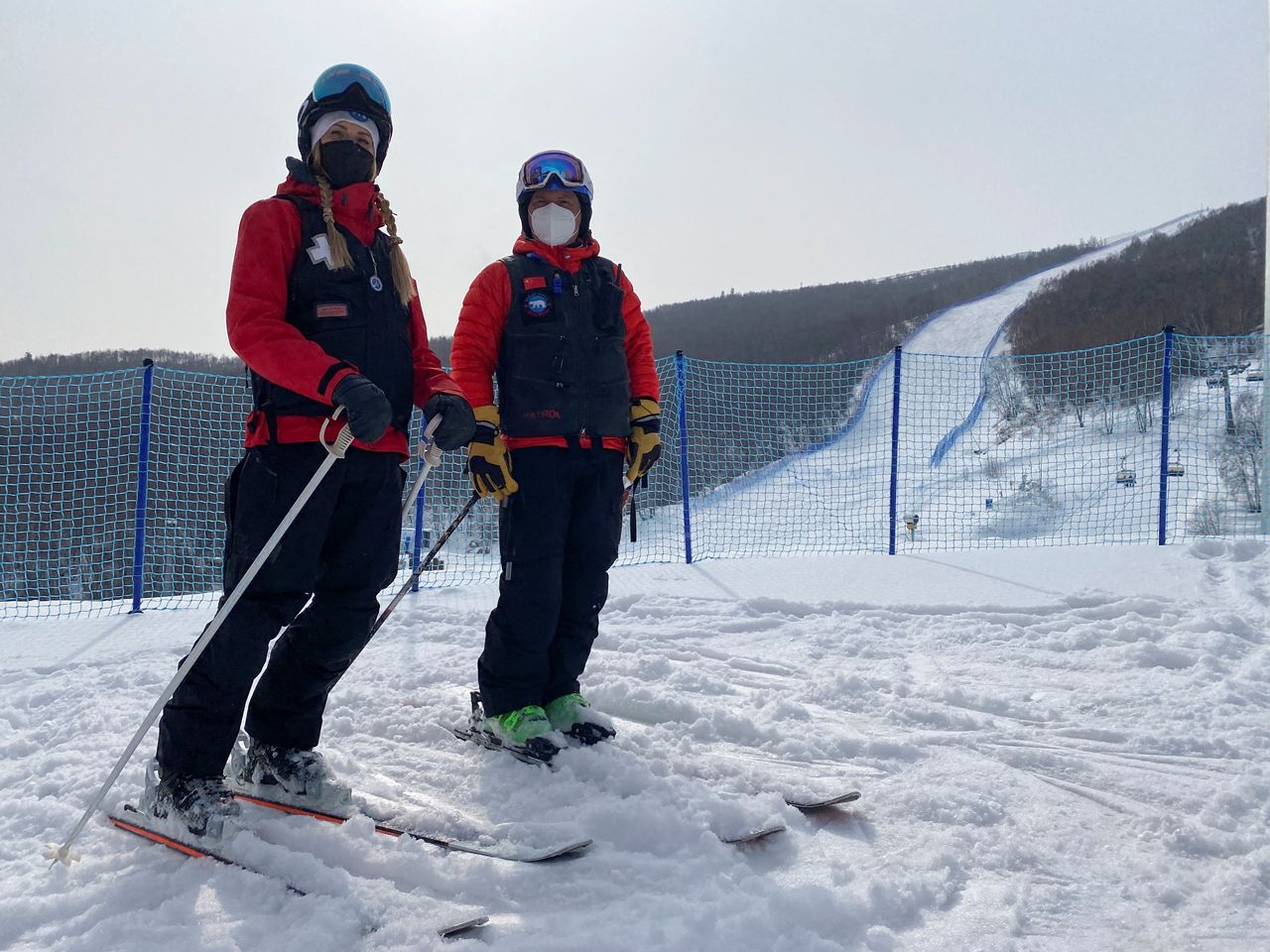 Canadian advanced care paramedic Kristen Slivorski, 36, and Polar Solutions Inc. President Richard Wyne, who are first responders for skiing and snowboarding events at the Beijing 2022 Winter Olympics, pose for photographs on skis while off-duty in Zhangjiakou, China, February 12, 2022. Picture taken February 12, 2022. REUTERS/Emily Roe