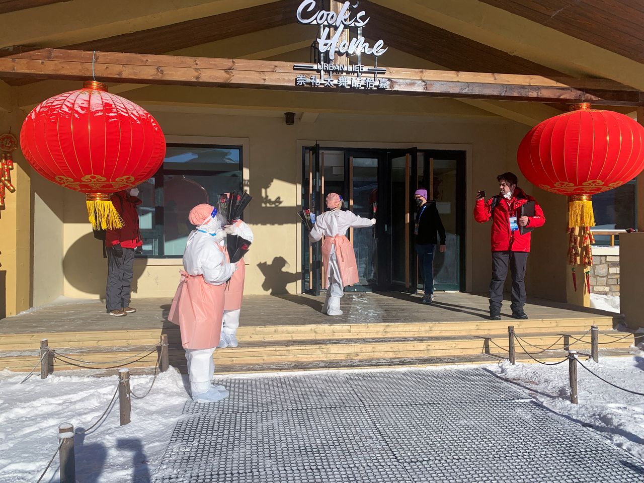 Beijing 2022 Winter Olympics volunteers hand out single red roses to journalists and personnel leaving a