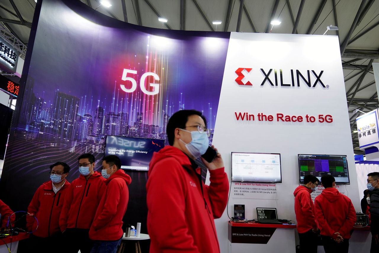 FILE PHOTO: Staff members stand at a Xilinx Inc booth at the Mobile World Congress (MWC) in Shanghai, China February 23, 2021. REUTERS/Aly Song/File Photo