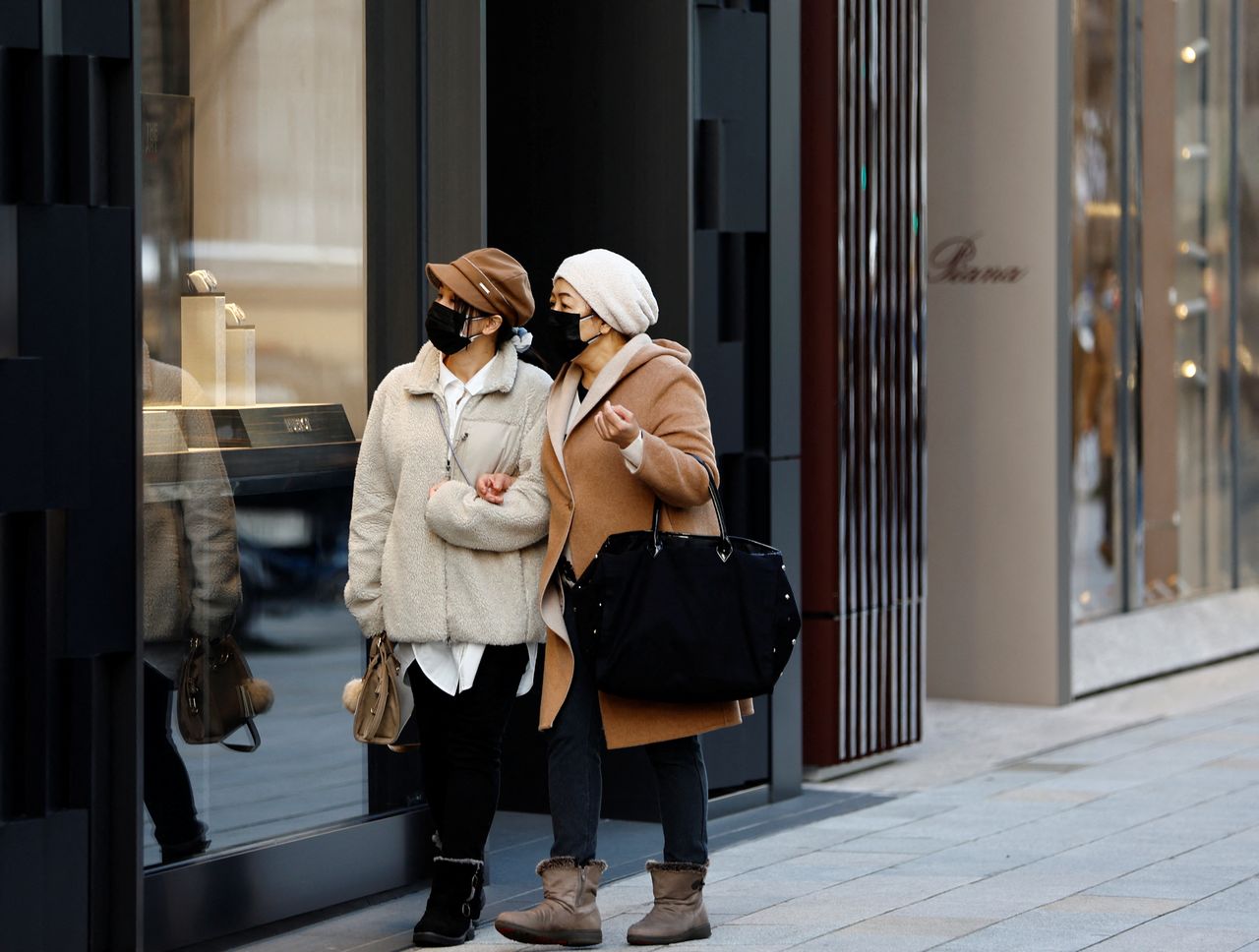 Women wearing protective masks look at the shop window of a luxury brand, amid the coronavirus disease (COVID-19) pandemic, at a shopping district in Tokyo, Japan, February 15, 2022. REUTERS/Kim Kyung-Hoon