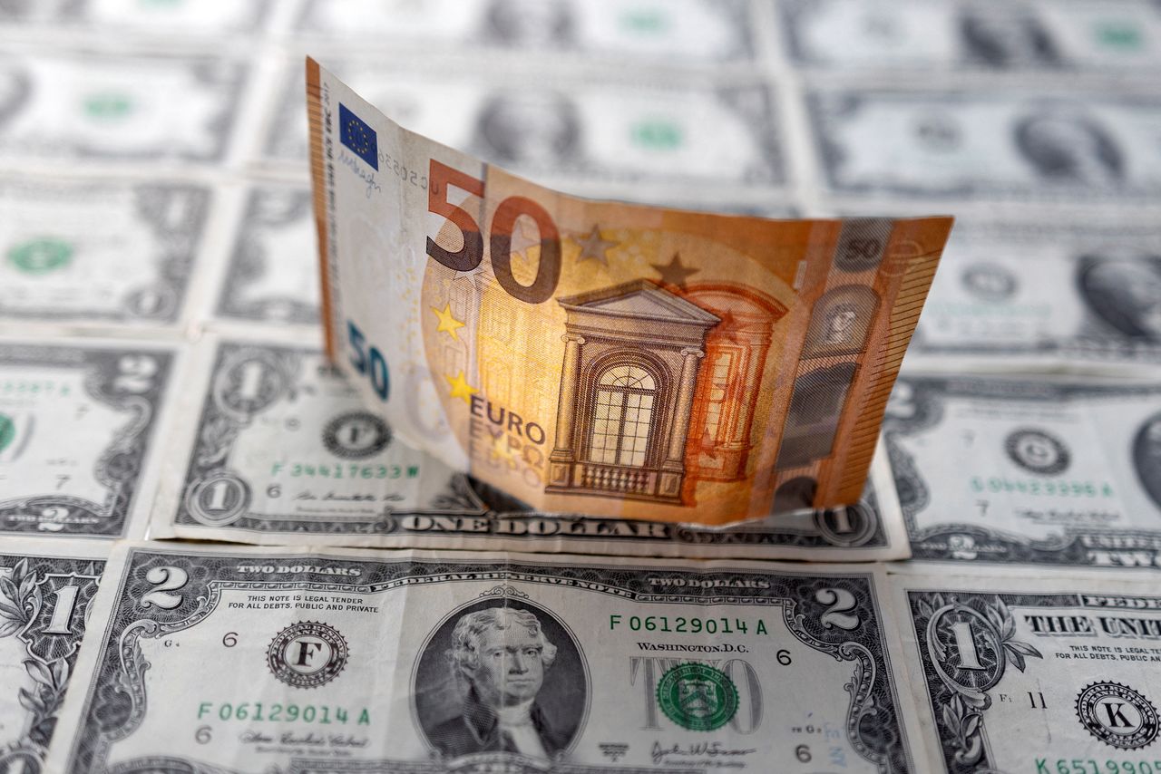 A Euro banknote is displayed on U.S. Dollar banknotes in this illustration taken, February 14, 2022. REUTERS/Dado Ruvic/Illustration