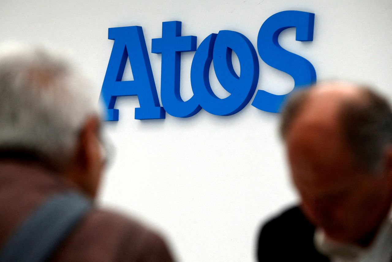 FILE PHOTO: People walk in front of the Atos company