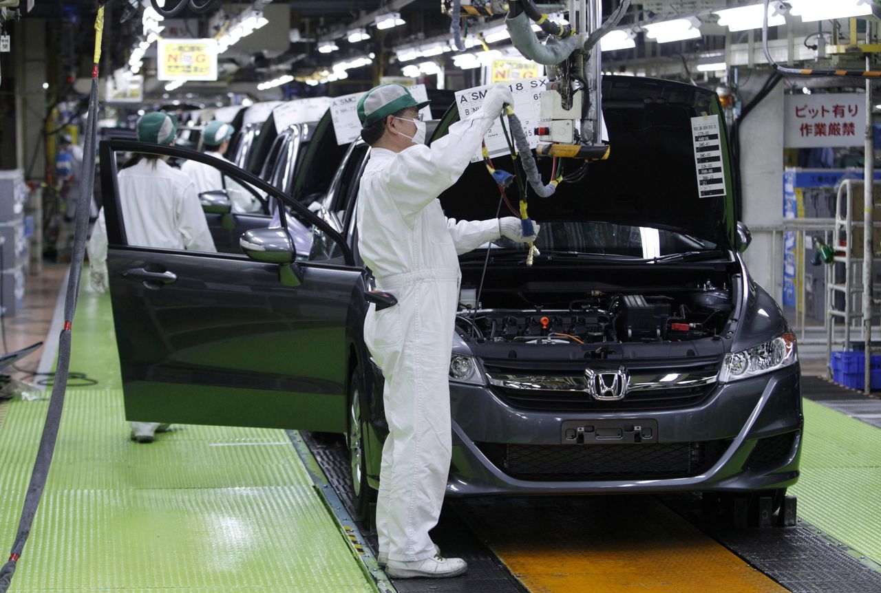 FILE PHOTO: Workers assemble cars at Honda Motor