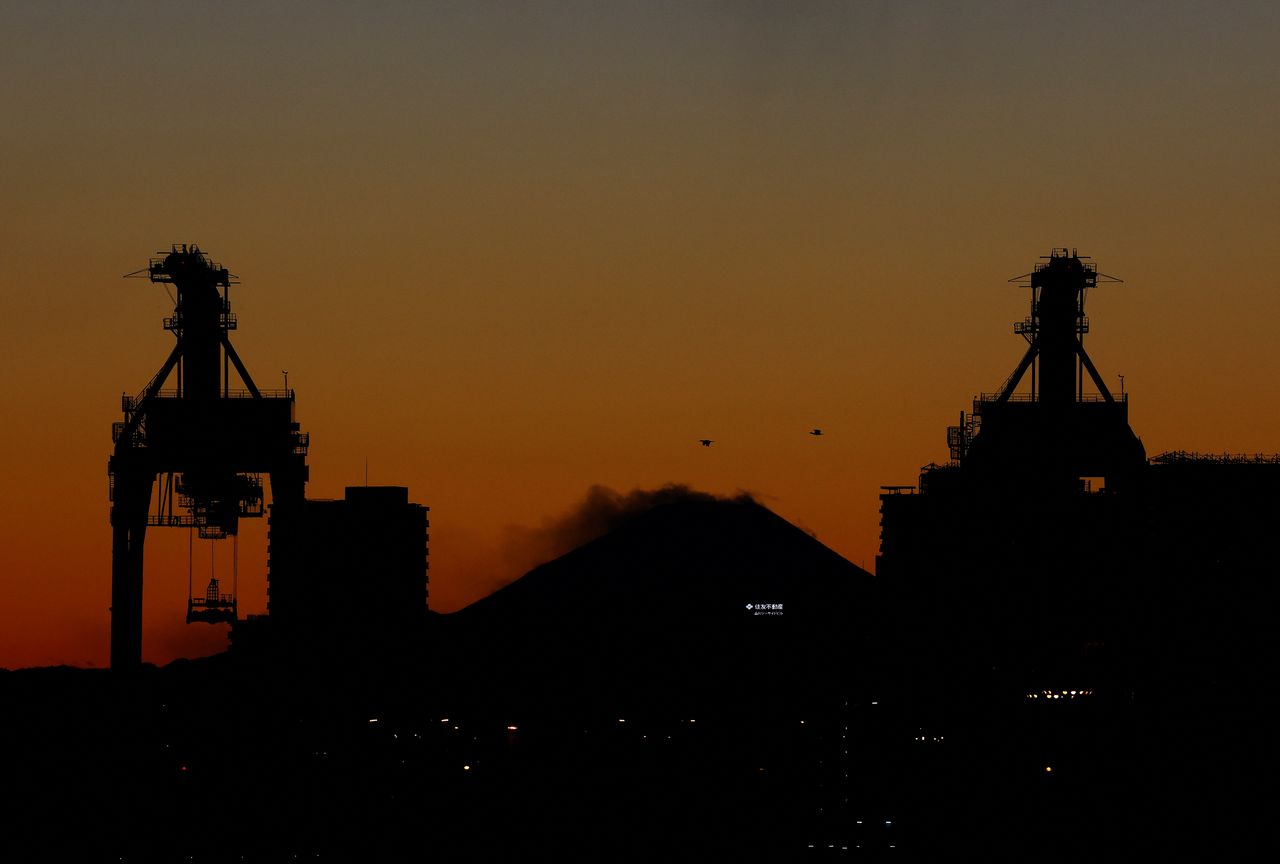 Cranes at an industrial port are seen in front of Mount Fuji in Tokyo, Japan, February 17, 2022. REUTERS/Kim Kyung-Hoon
