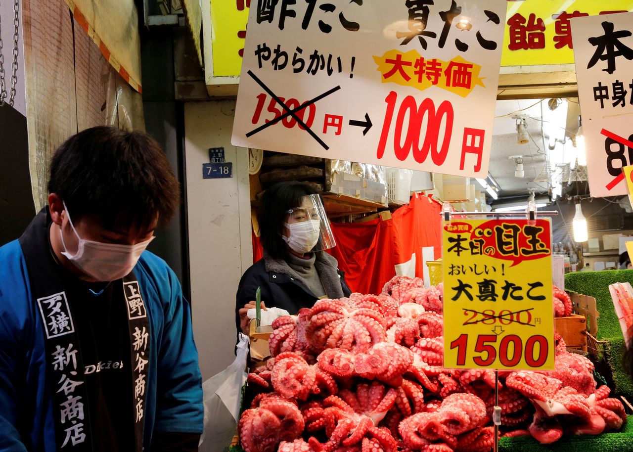 FILE PHOTO: Vendors wearing protective masks amid the coronavirus disease (COVID-19) outbreak, sell seafood at Ameyoko shopping district in Tokyo, Japan, December 29, 2020. REUTERS/Kim Kyung-Hoon/