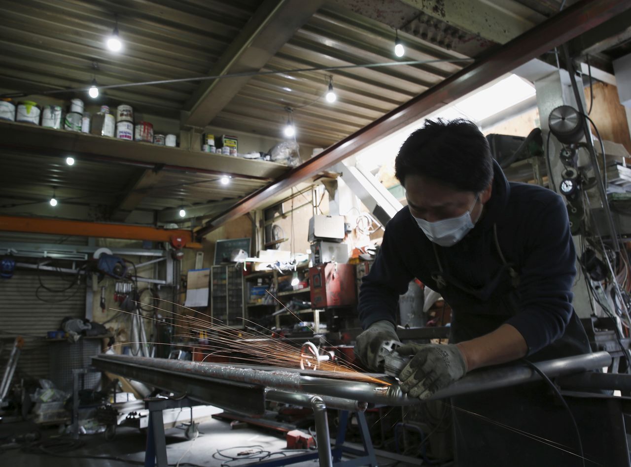FILE PHOTO: An engineer makes an arm rail for residential buildings inside a metal processing factory at an industrial zone in downtown Tokyo, Japan, March 22, 2016. REUTERS/Yuya Shino