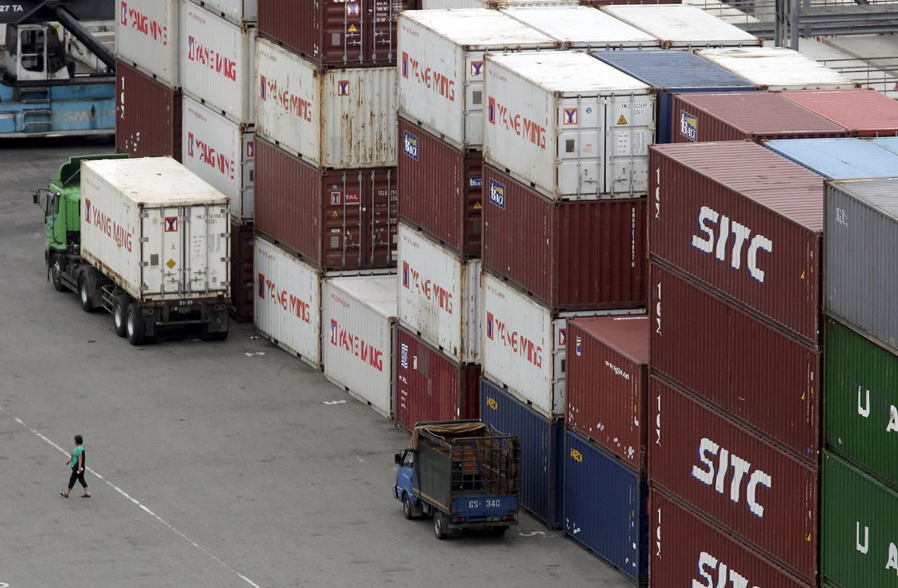 FILE PHOTO: A person walks near containers at Keelung port, northern Taiwan, October 30, 2015. REUTERS/Pichi Chuang