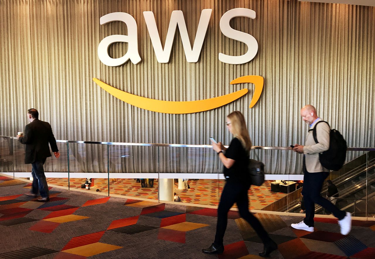 FILE PHOTO: Attendees at Amazon.com Inc annual cloud computing conference walk past the Amazon Web Services logo in Las Vegas, Nevada, U.S., November 30, 2017.  REUTERS/Salvador Rodriguez/File Photo