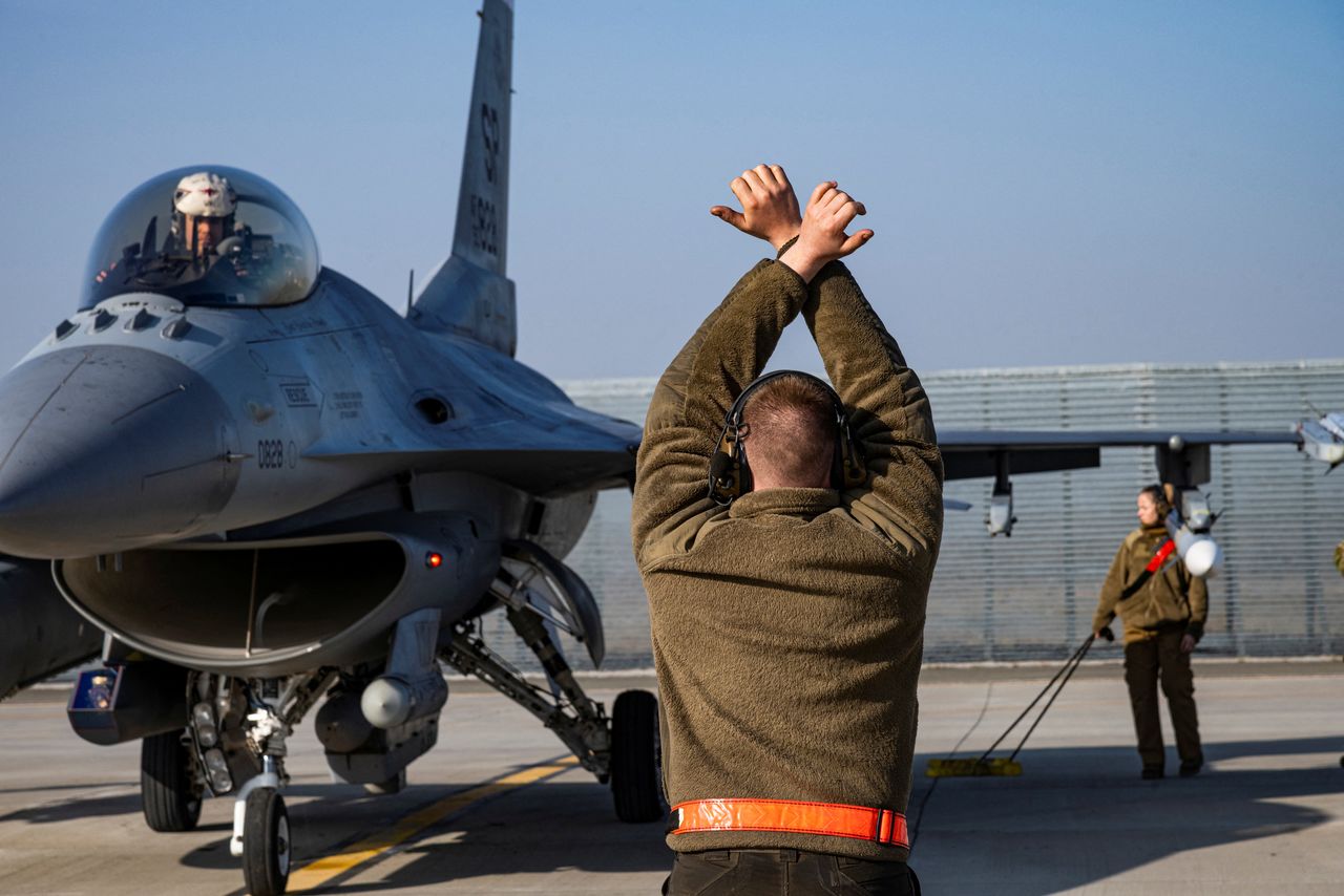 A U.S. Air Force airman marshals an F-16 Fighting Falcon aircraft assigned to the 480th Fighter Squadron, at the 86th Air Base near Fetesti, Romania, February 17, 2022. Picture taken February 17, 2022. U.S. Air Force/Senior Airman Ali Stewart/Handout via REUTERS.