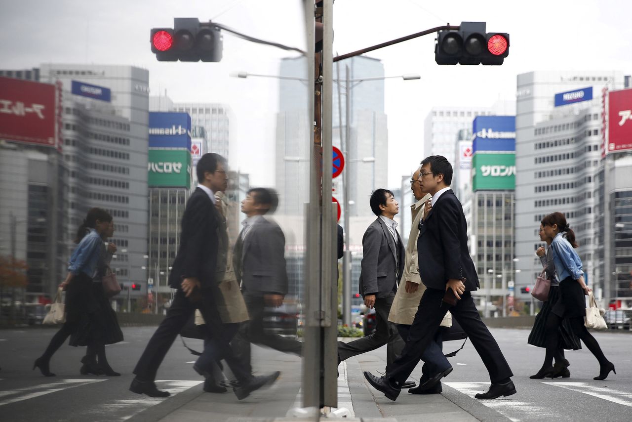 FILE PHOTO: People cross a street in a business district in central Tokyo, Japan, December 8, 2015.REUTERS/Thomas Peter