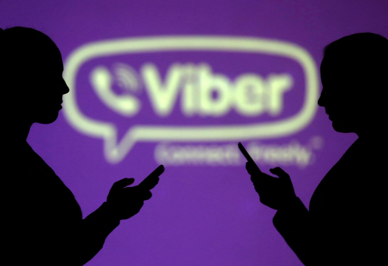 FILE PHOTO: Silhouettes of mobile users are seen next to a screen projection of Viber logo in this picture illustration taken March 28, 2018.  REUTERS/Dado Ruvic/Illustration/File Photo