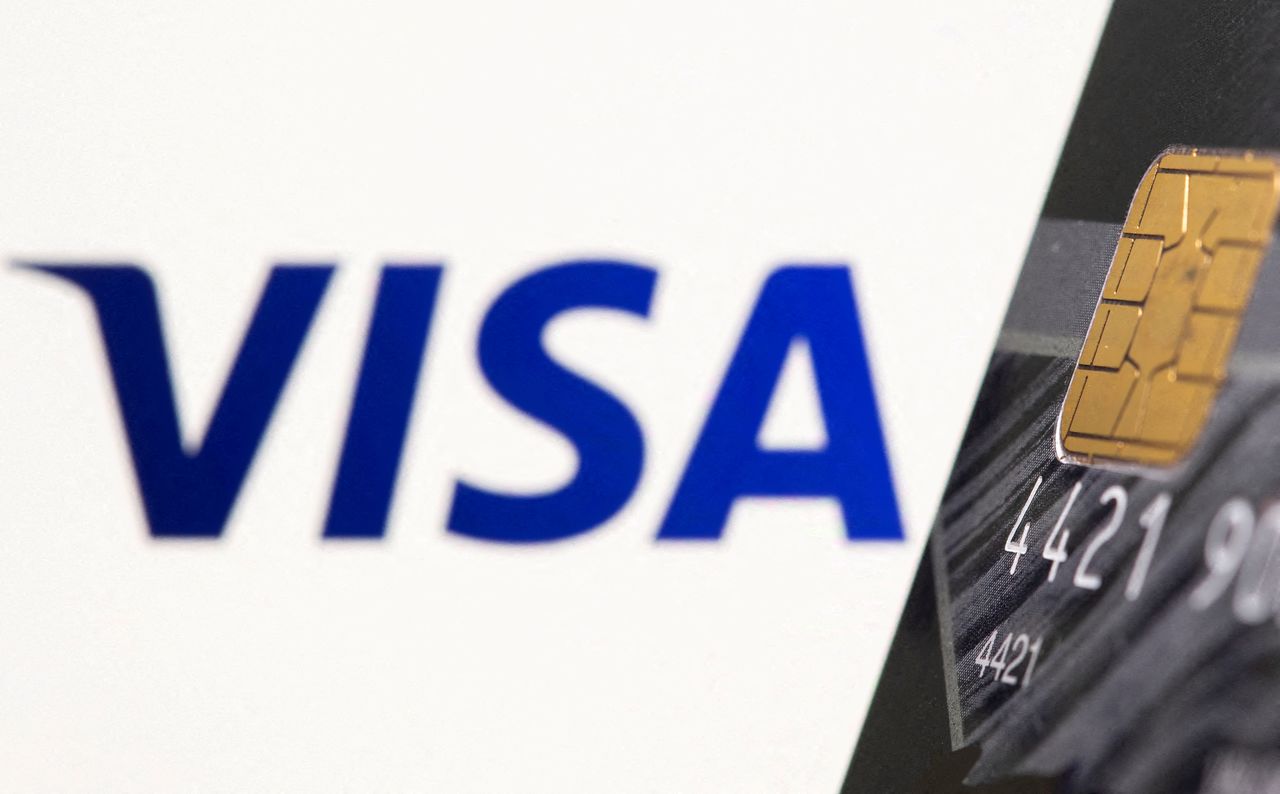 FILE PHOTO: Credit card is seen in front of displayed Visa logo in this illustration taken July 15, 2021. REUTERS/Dado Ruvic/Illustration