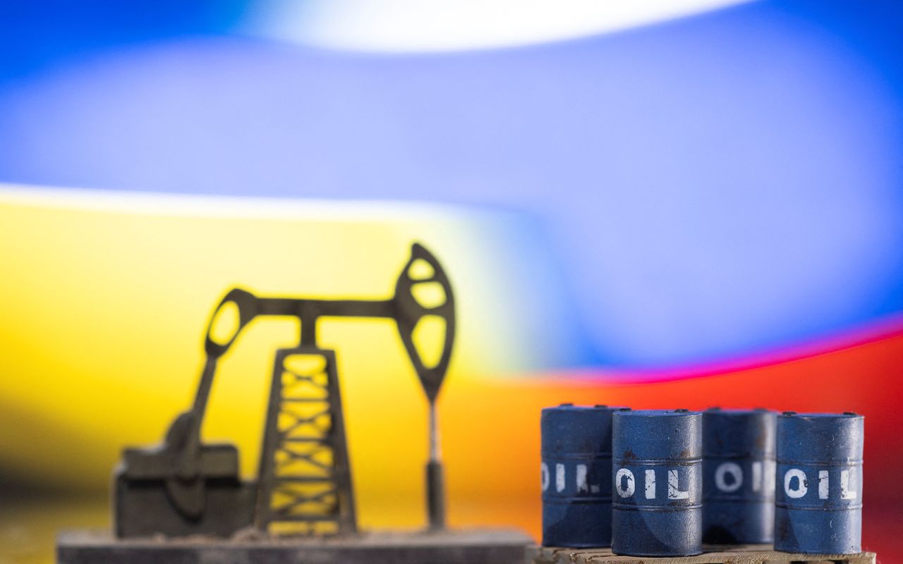 FILE PHOTO: Models of oil barrels and a pump jack are displayed in front of Ukrainian and Russian flag colors in this illustration taken, February 24, 2022. REUTERS/Dado Ruvic/Illustration