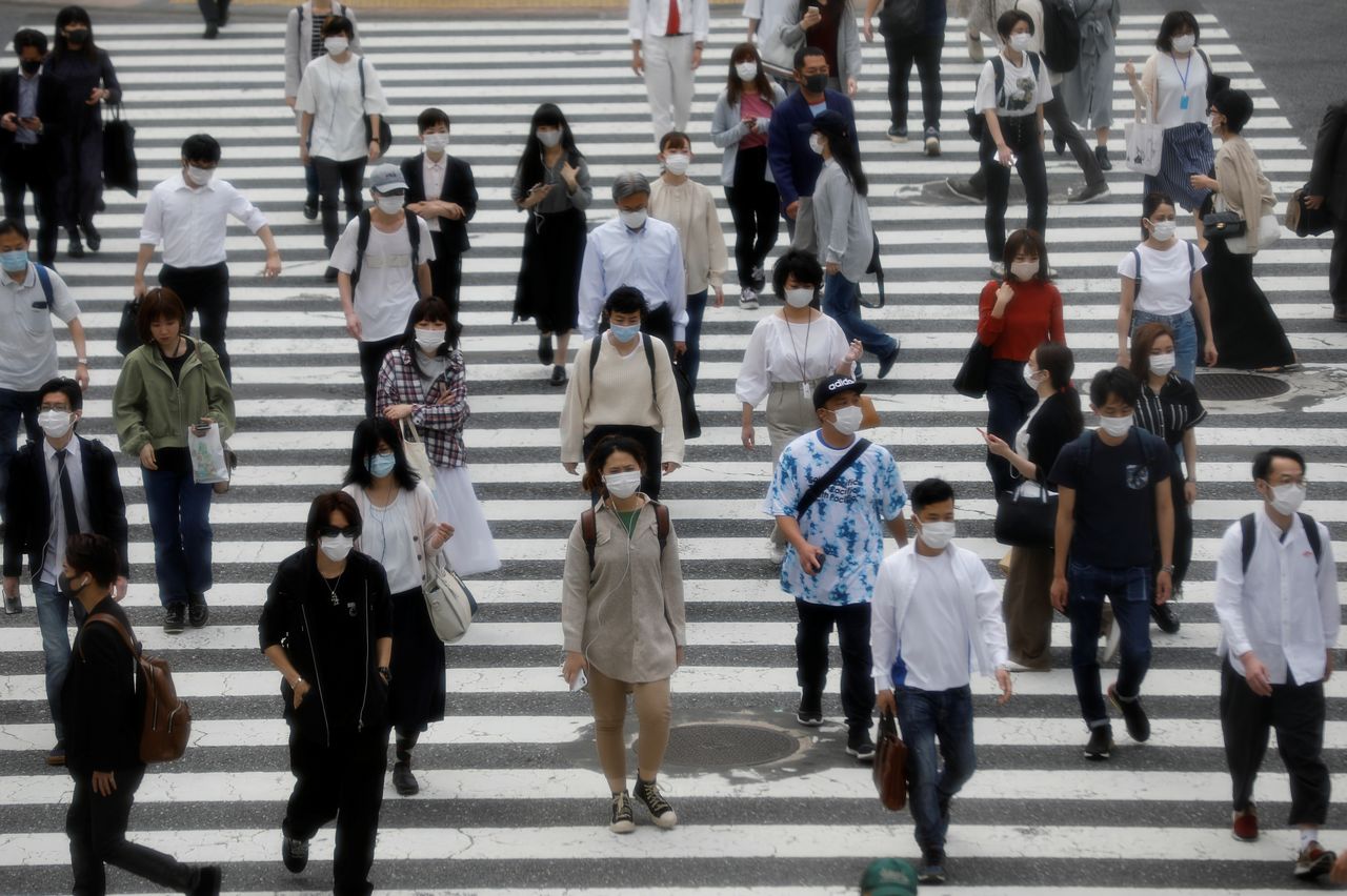 People wearing protective face masks cross a street amid the coronavirus disease (COVID-19) outbreak in Tokyo, Japan, May 27, 2020.REUTERS/Kim Kyung-Hoon