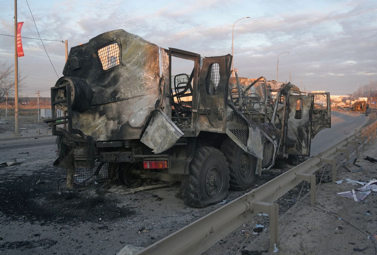 A charred military vehicle is seen on a road, as Russia