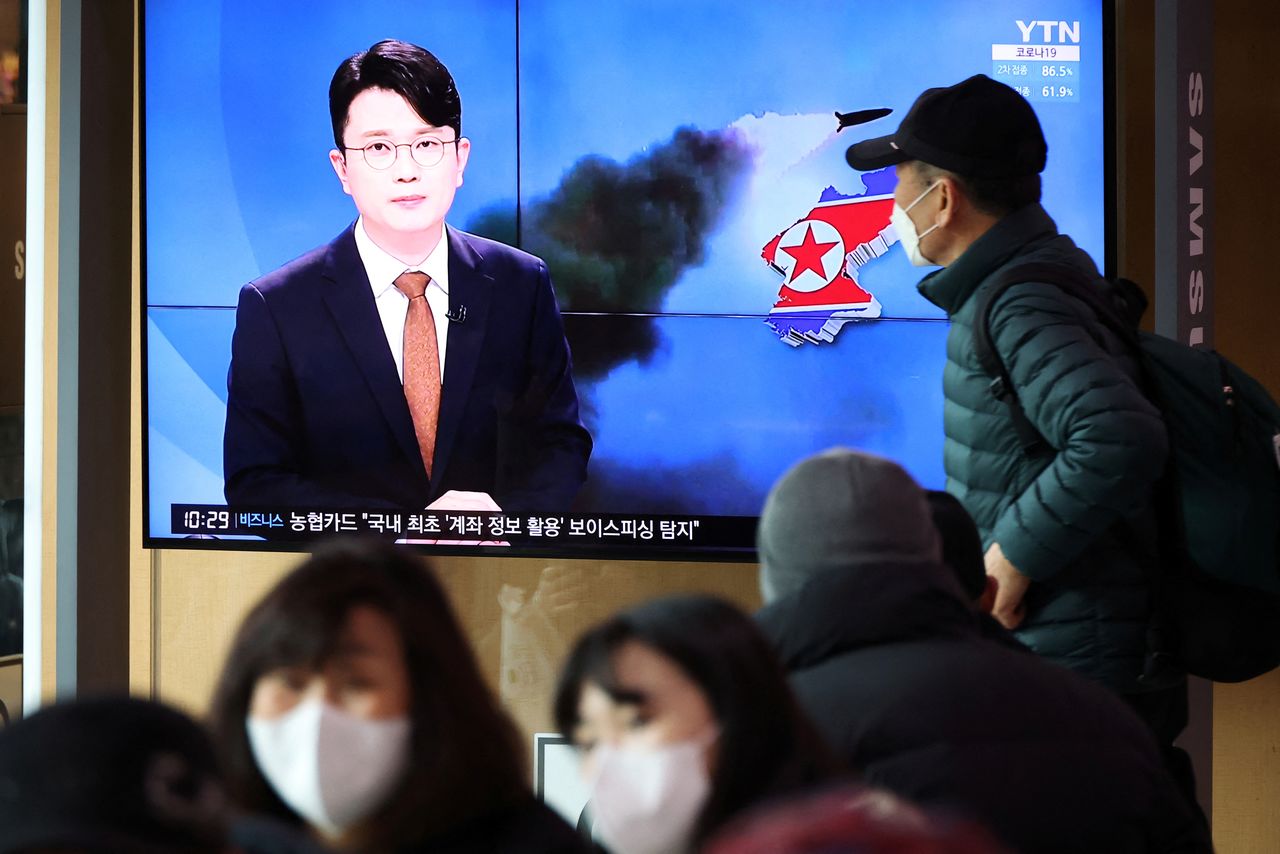 FILE PHOTO: People watch a TV broadcasting a news report on North Korea