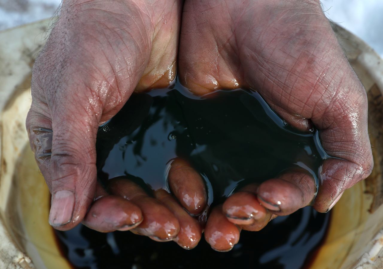 An employee demonstrates a sample of crude oil in the Yarakta Oil Field, Russia in this picture illustration taken March 11, 2019. REUTERS/Vasily Fedosenko