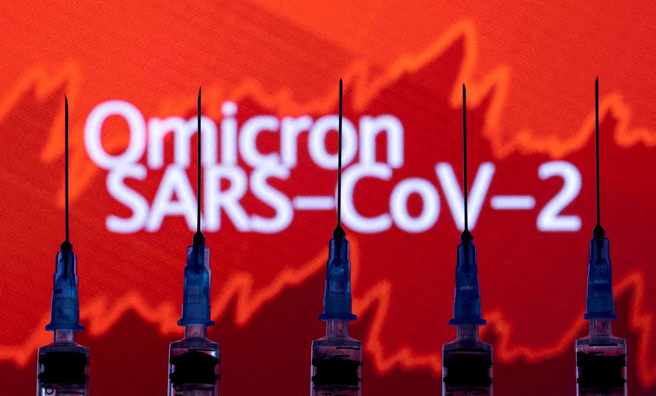 FILE PHOTO: Syringes with needles are seen in front of a displayed stock graph and words "Omicron SARS-CoV-2" in this illustration taken November 27, 2021. REUTERS/Dado Ruvic