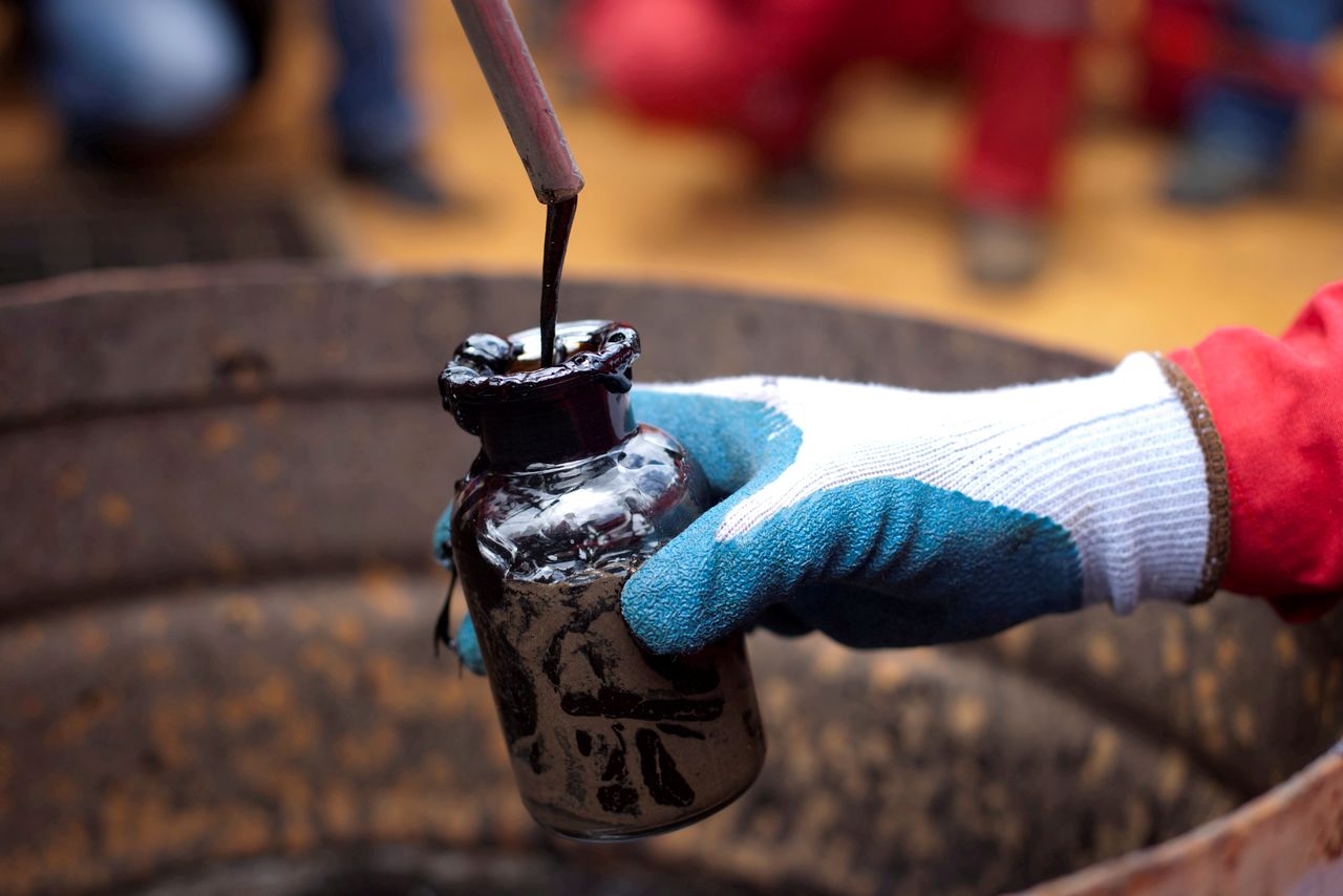 FILE PHOTO: A worker collects a crude oil sample at an oil well operated by Venezuela