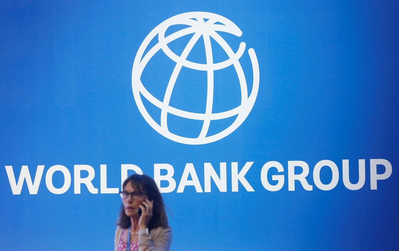 FILE PHOTO: A participant stands near a logo of World Bank at the International Monetary Fund - World Bank Annual Meeting 2018 in Nusa Dua, Bali, Indonesia, October 12, 2018. REUTERS/Johannes P. Christo