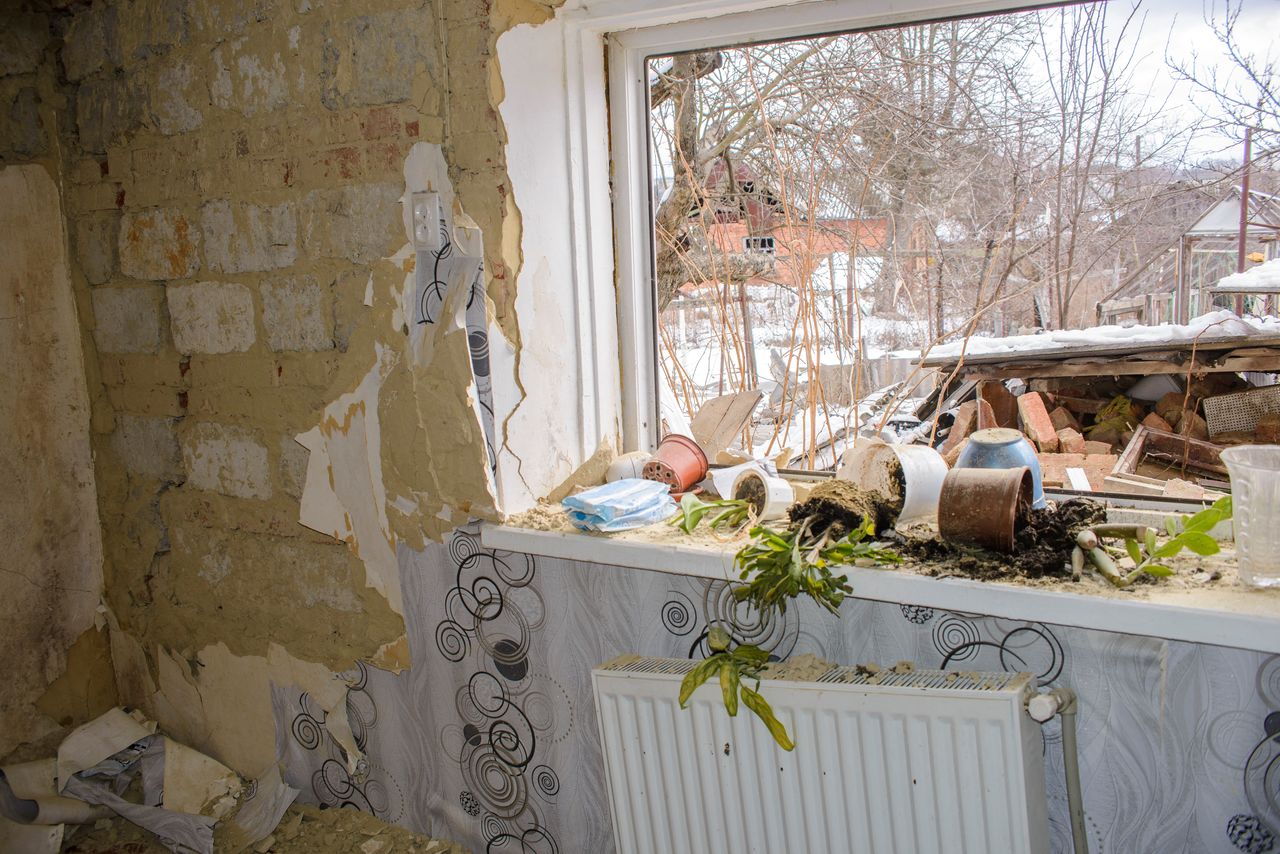 A detail view shows the interior of a house destroyed by shelling, amid Russia