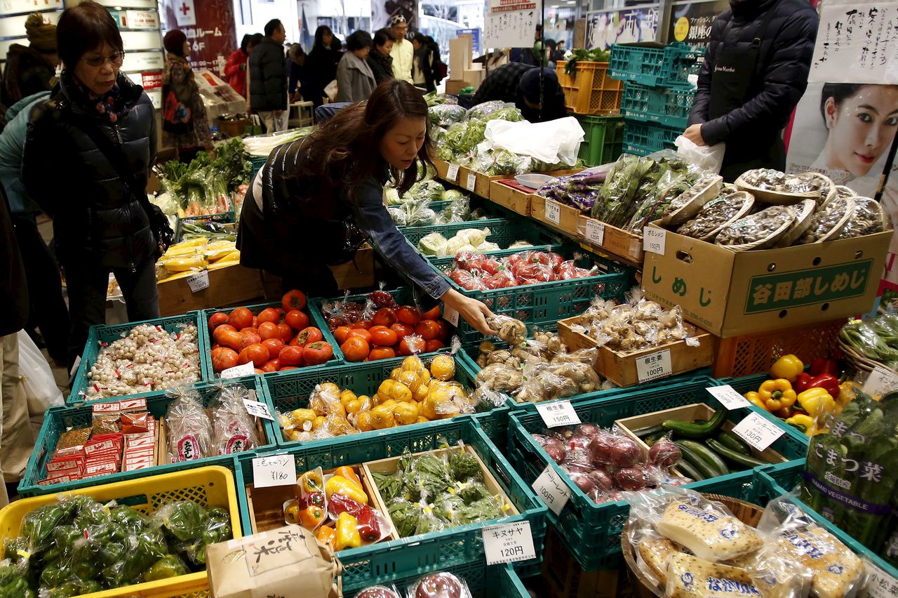 A shopper looks at packs of vegetables at a market at a shopping district in Tokyo, Japan, December 6, 2015. Picture taken December 6, 2015. To match JAPAN-ECONOMY/TANKAN REUTERS/Yuya Shino