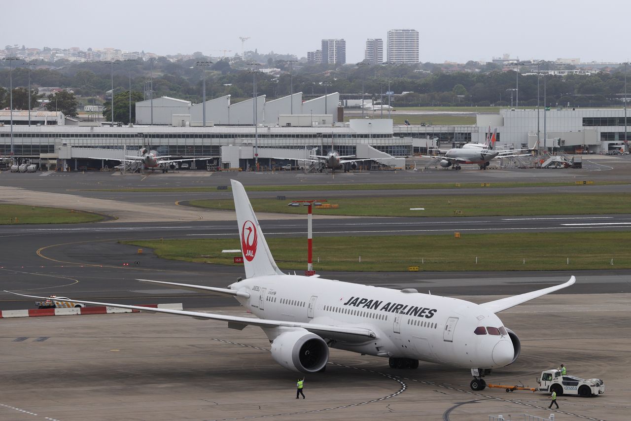 FILE PHOTO: A Japan Airlines plane is seen from the international terminal at Sydney Airport, as countries react to the new coronavirus Omicron variant amid the coronavirus disease (COVID-19) pandemic, in Sydney, Australia, November 30, 2021. REUTERS/Loren Elliott