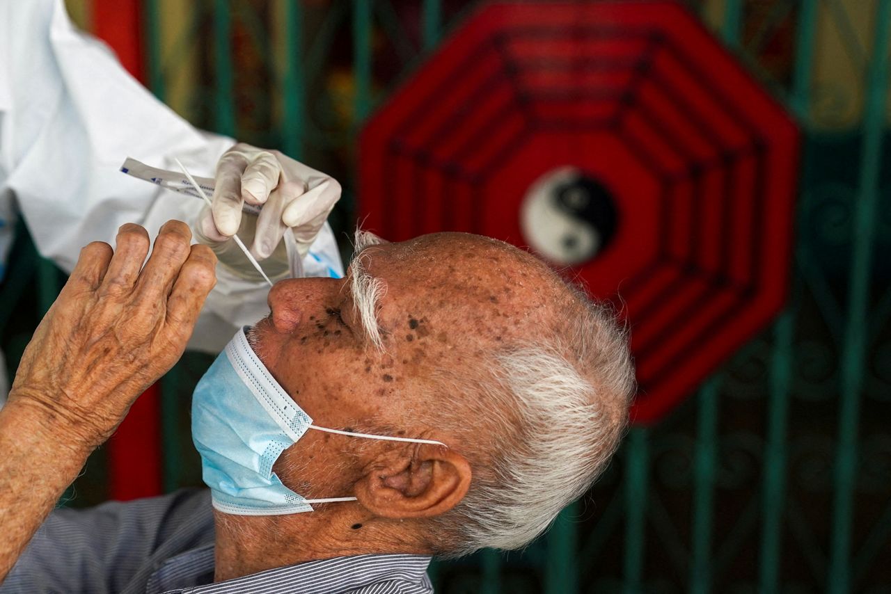 FAILOS NUOTRAUKA: Sveikatos apsaugos darbuotojas iš Zendai organizacijos, naudodamas asmenines apsaugos priemones (AAP), paima tampono mėginį iš vyro greitajam antigeno tyrimui koronaviruso ligos (COVID-19) protrūkio metu Bankoke, Tailande, 2022 m. sausio 5 d. REUTERS. / Athit Perawongmetha