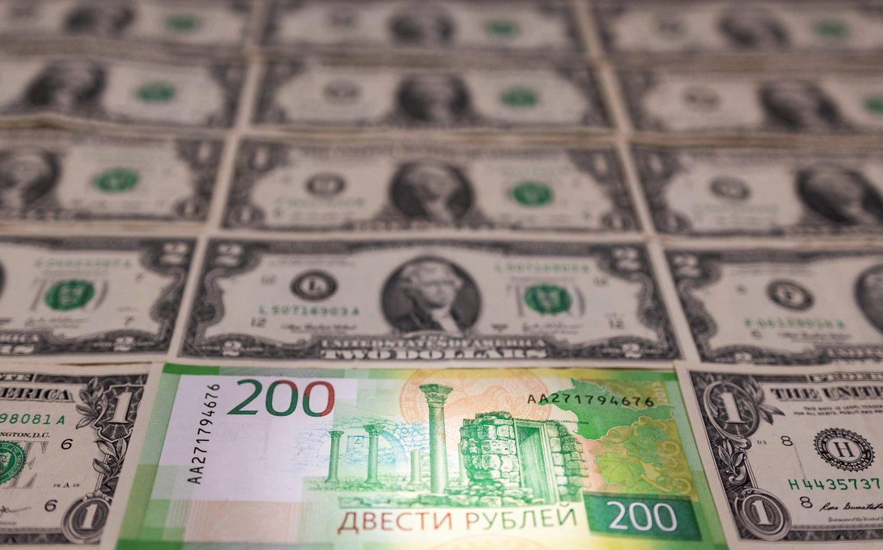Russian Rouble banknote is placed on U.S. Dollar banknotes in this illustration taken, February 24, 2022. REUTERS/Dado Ruvic/Illustration