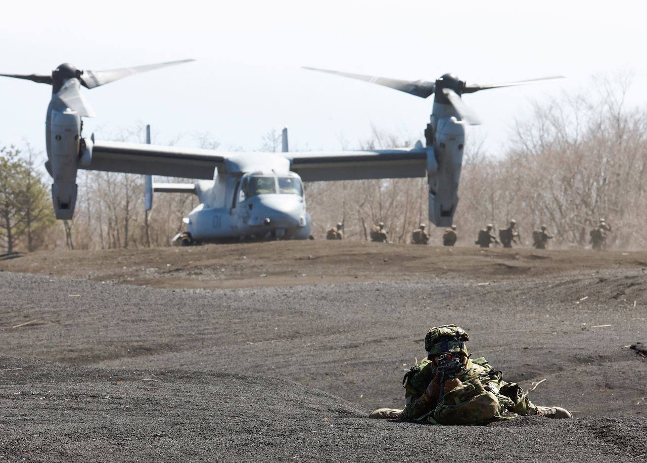 A member of the Japanese Self-Defense Force’s Amphibious Rapid Deployment Brigade takes a position while U.S. Marine Corps members get out of its MV-22 Osprey during a joint airborne landing exercise with the U.S. Marine Corps in Gotemba, west of Tokyo, Japan March 15, 2022. REUTERS/Kim Kyung-Hoon