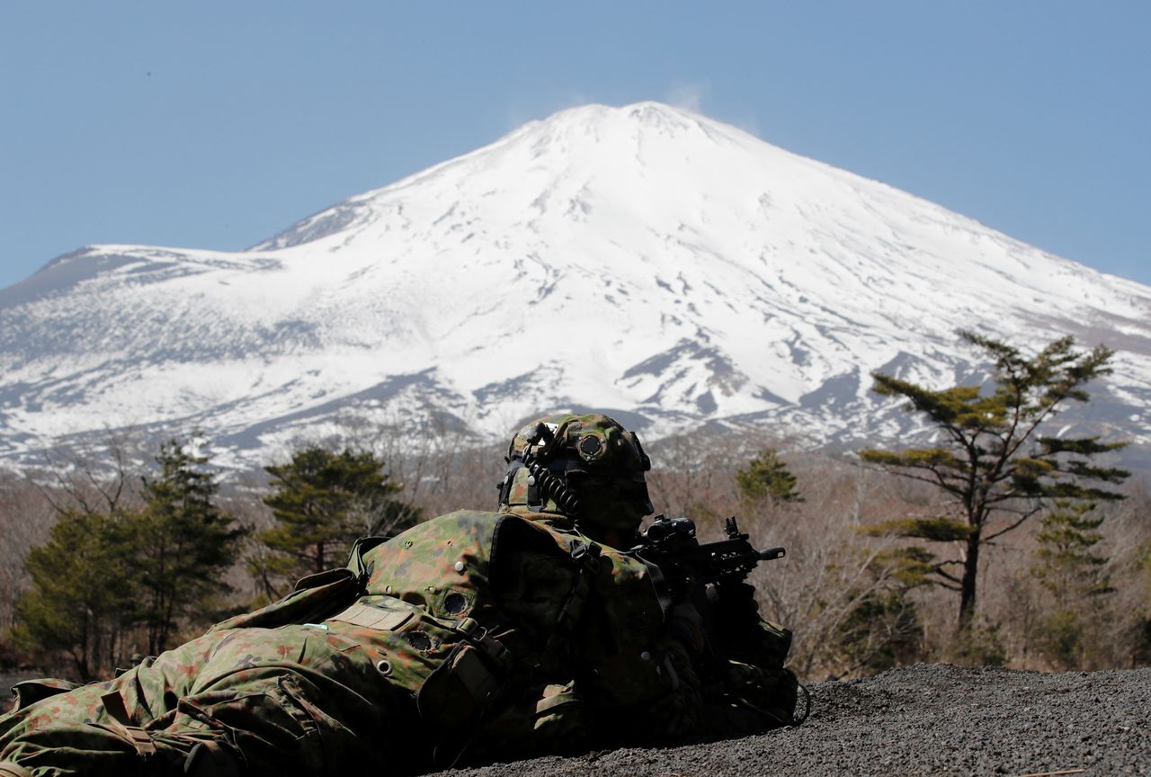 Mt.Fuji is seen while a member of the Japanese Self-Defense Force’s Amphibious Rapid Deployment Brigade takes a position during a joint airborne landing exercises with U.S.Marine Corps near Mount Fuji at Higashifuji training field in Gotemba, west of Tokyo, Japan March 15,  2022. REUTERS/Kim Kyung-Hoon