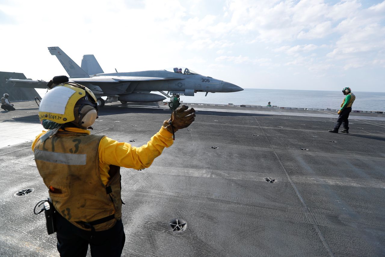 FILE PHOTO: Shooter and Controler prepare an F/A-18E Super Hornet to be catapulted off from the flight deck of the aircraft carrier USS Abraham Lincoln in the Gulf, November 23, 2019. REUTERS/Hamad I Mohammed/File Photo