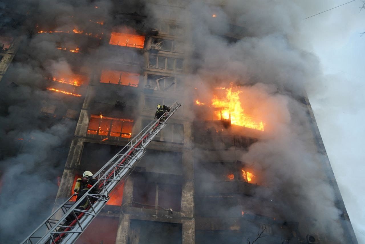 Rescuers work next to a residential building damaged by shelling, as Russia
