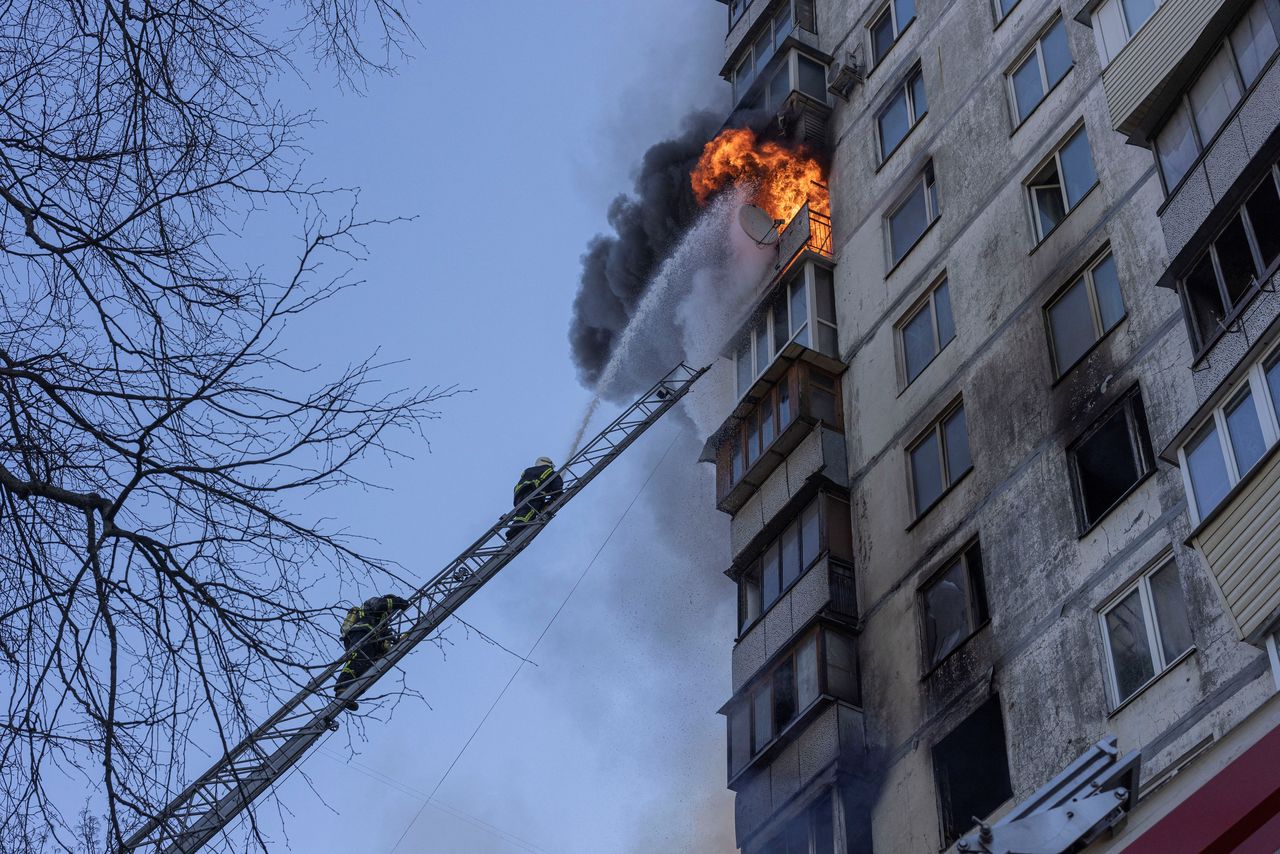 Firefighters work to put out a fire in a residential apartment building after it was hit by shelling as Russia