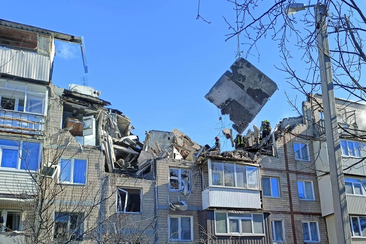 Rescuers remove debris from a residential building damaged by an airstrike, as Russia