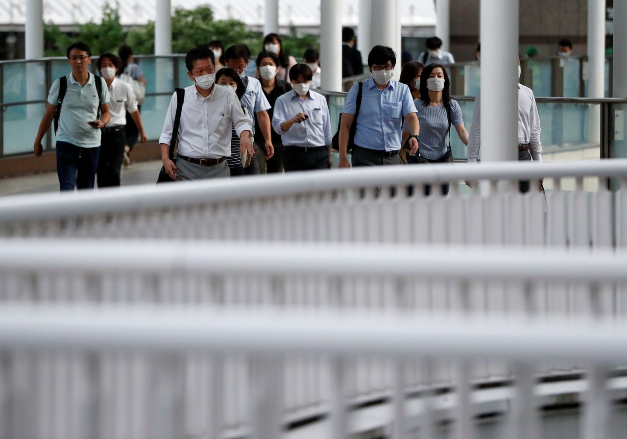 Office workers wearing protective face masks head home during the spread of the coronavirus disease (COVID-19), at a station in Tokyo, Japan June 24, 2020.  REUTERS/Issei Kato