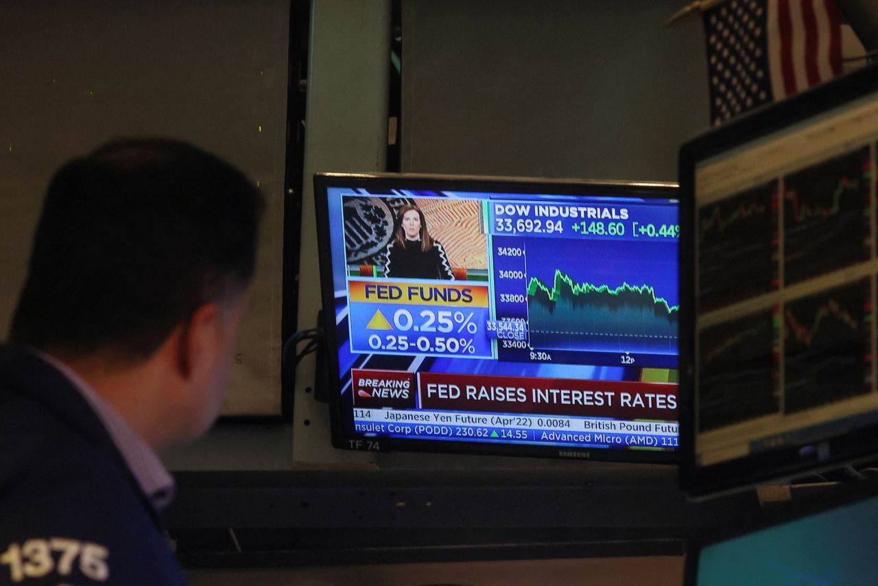 A screen displays the Fed rate announcement as traders work on the floor of the New York Stock Exchange (NYSE) in New York City, U.S., March 16, 2022.  REUTERS/Brendan McDermid