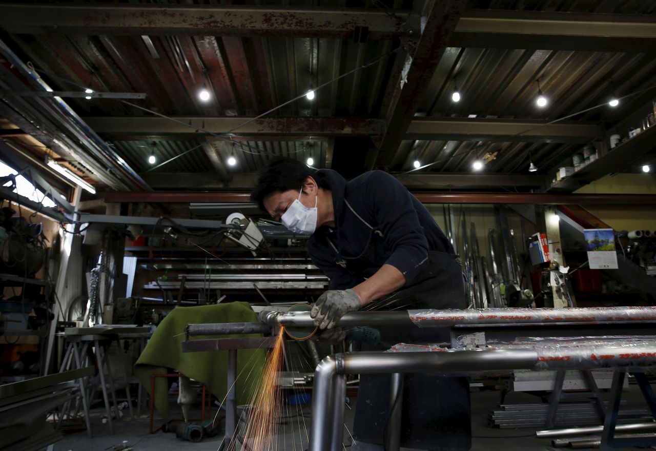 An engineer makes an arm rail for residential buildings inside a metal processing factory at an industrial zone in downtown Tokyo, Japan, March 22, 2016. REUTERS/Yuya Shino