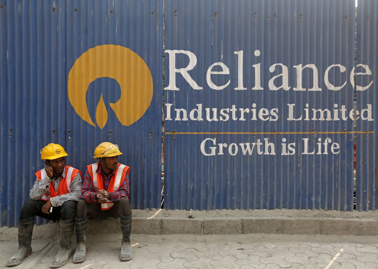 FILE PHOTO: Labourers rest in front of an advertisement of Reliance Industries Limited at a construction site in Mumbai, India, March 2, 2016. REUTERS/Shailesh Andrade