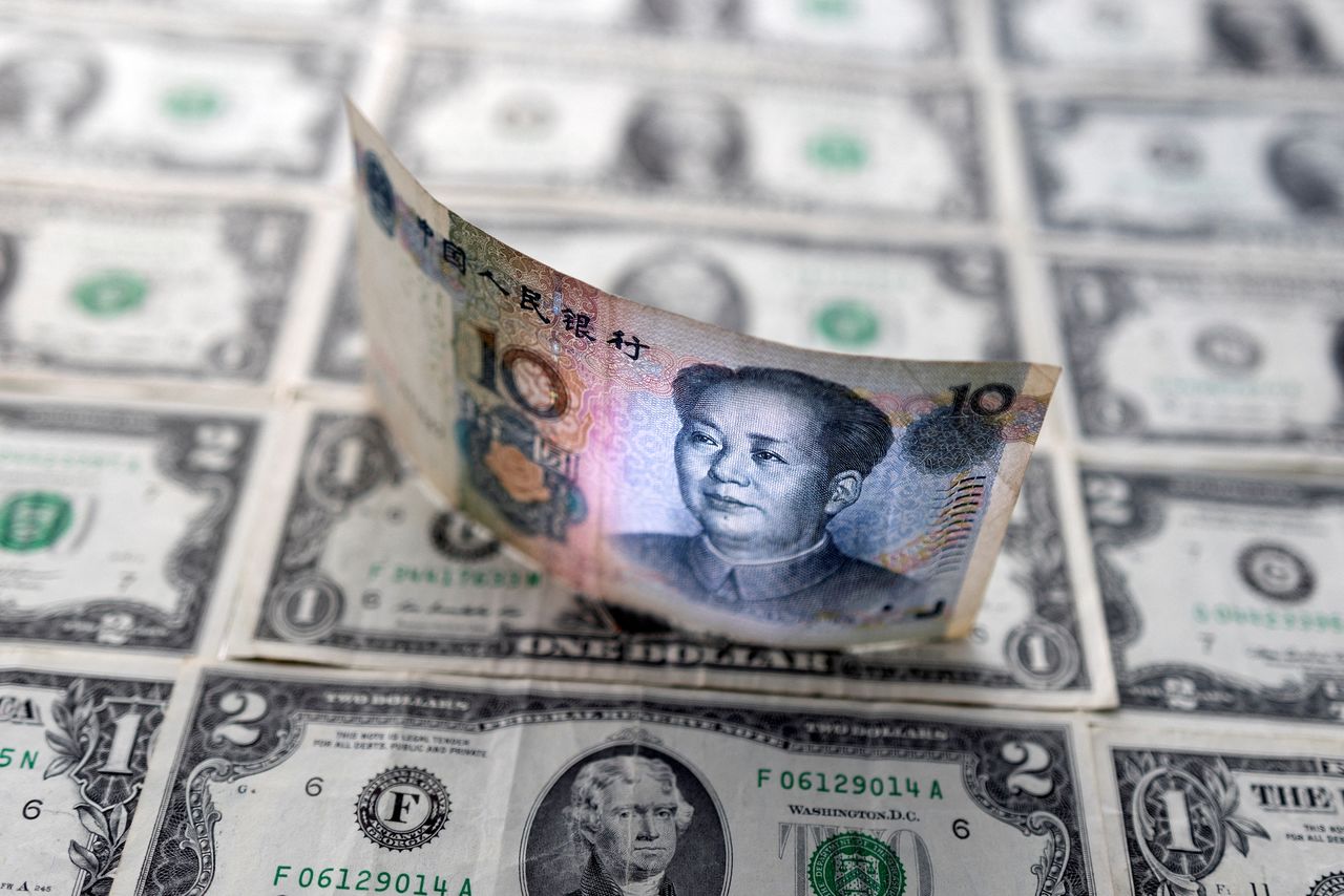 FILE PHOTO: Chinese yuan banknote is displayed on U.S. Dollar banknotes in this illustration taken, February 14, 2022. REUTERS/Dado Ruvic/Illustration