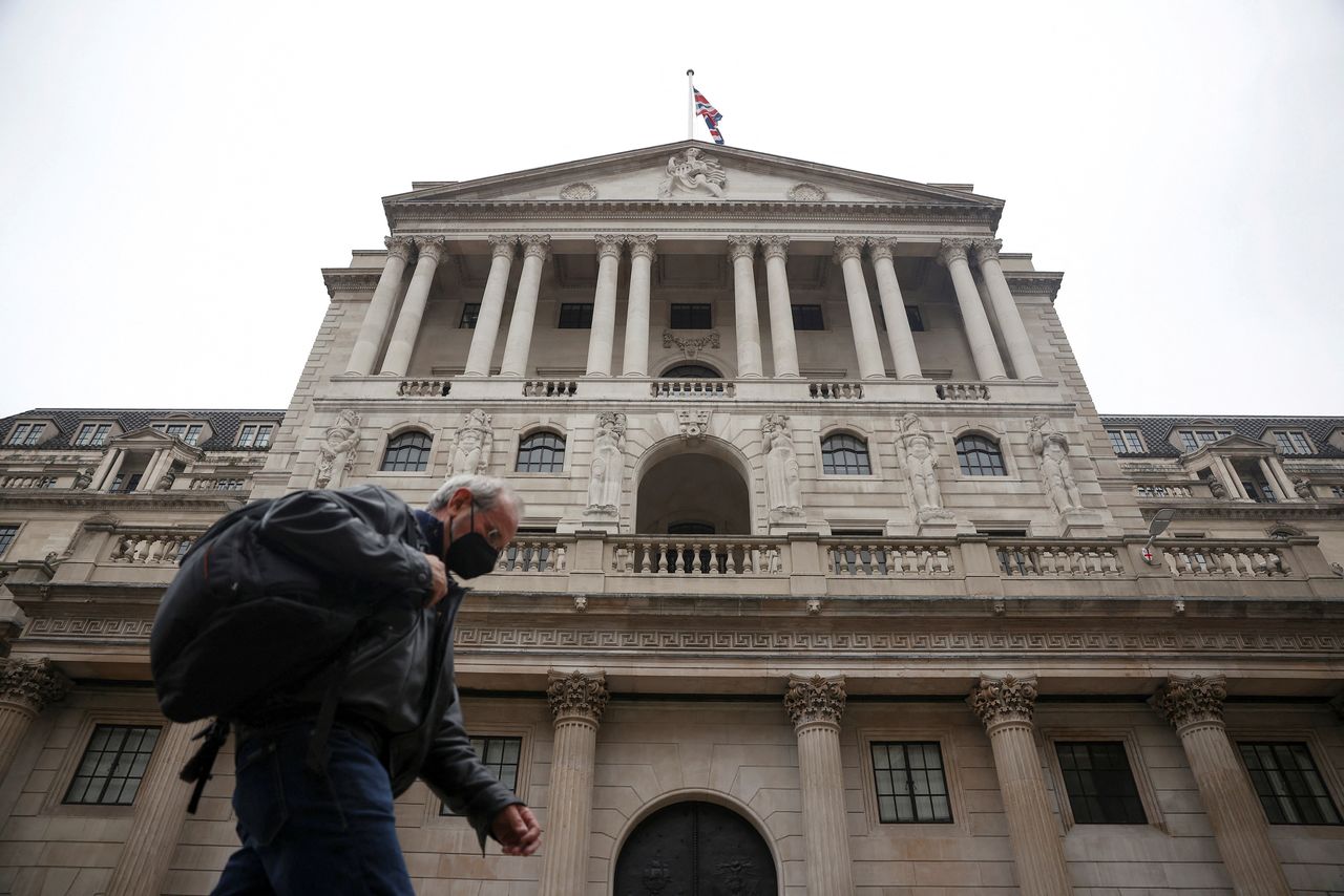 FILE PHOTO: A person walks past the Bank of England in the City of London financial district in London, Britain, January 23, 2022. REUTERS/Henry Nicholls