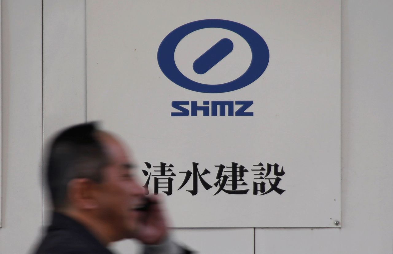 FILE PHOTO: A man walks past the logo of Shimizu Corp outside a construction site in Tokyo, Japan, December 18, 2017.  REUTERS/Toru Hanai