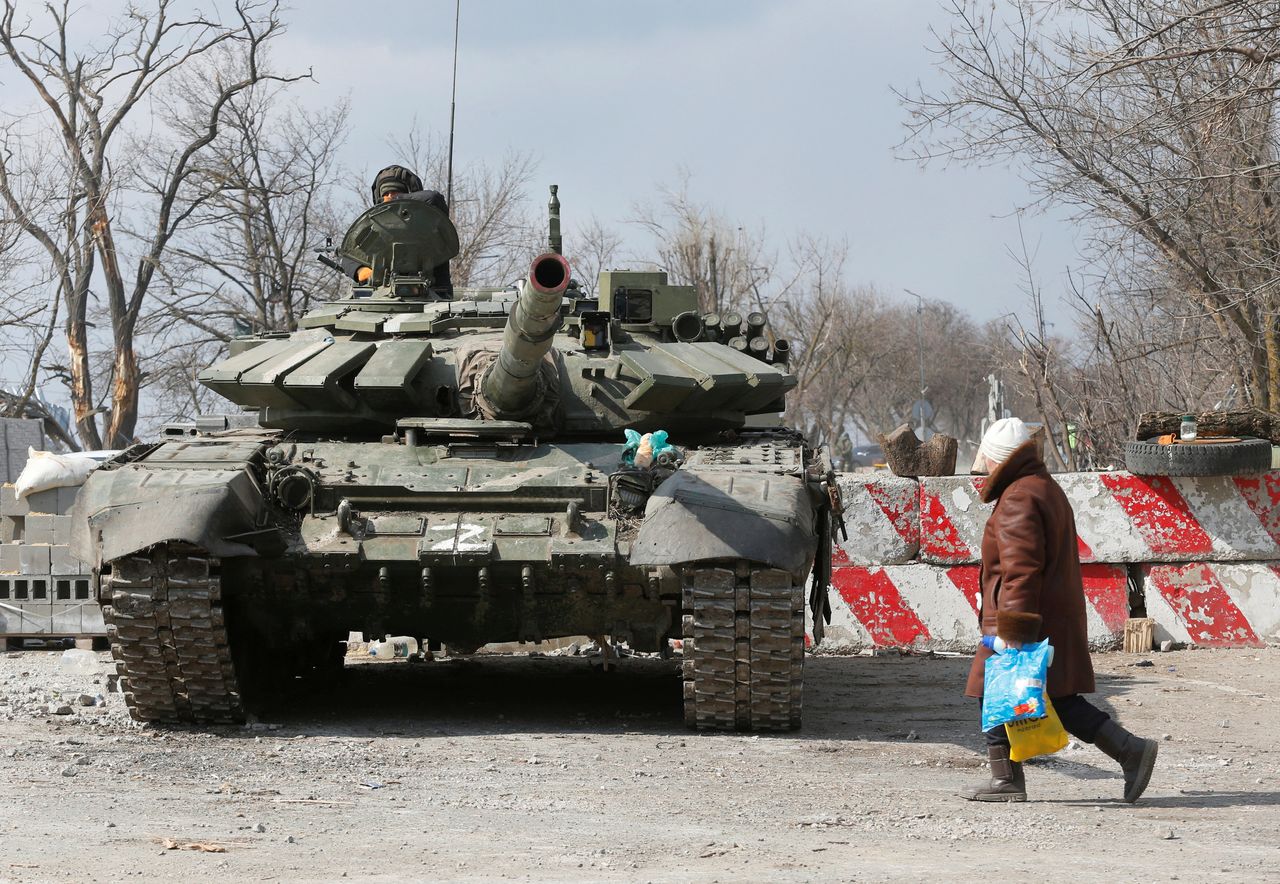 A local resident walks past a tank of pro-Russian troops during Ukraine-Russia conflict in the besieged southern port city of Mariupol, Ukraine March 18, 2022. REUTERS/Alexander Ermochenko