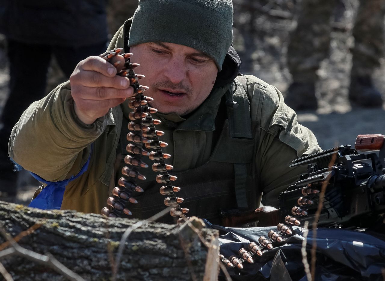 A Ukrainian service member checks cartridges for a machine gun at a position on the front line in the north Kyiv region, Ukraine March 18, 2022. REUTERS/Gleb Garanich