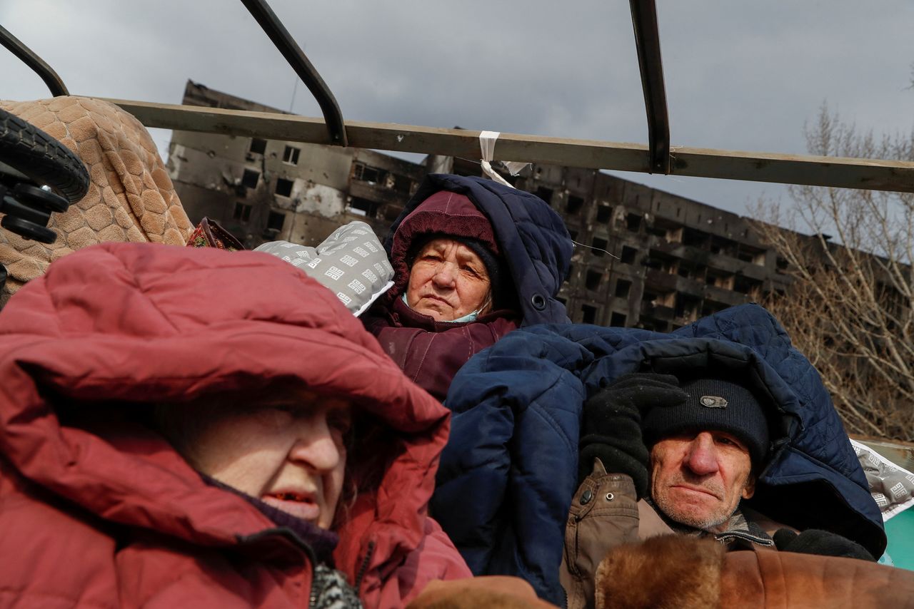 Evacuees fleeing Ukraine-Russia conflict sit in the body of a cargo vehicle while waiting in a line to leave the besieged southern port city of Mariupol, Ukraine March 17, 2022. REUTERS/Alexander Ermochenko
