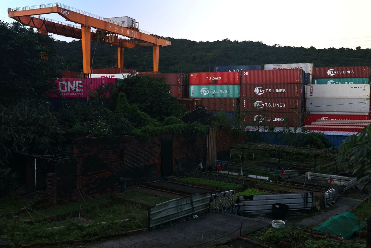 FILE PHOTO: Cargo cranes are seen moving containers at a container yard in Keelung, Taiwan, November 18, 2020. REUTERS/Ann Wang