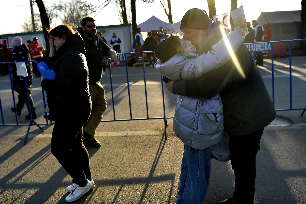 A woman cries as her daughter embraces her husband after fleeing from Kharkiv in Ukraine to Romania, following Russia
