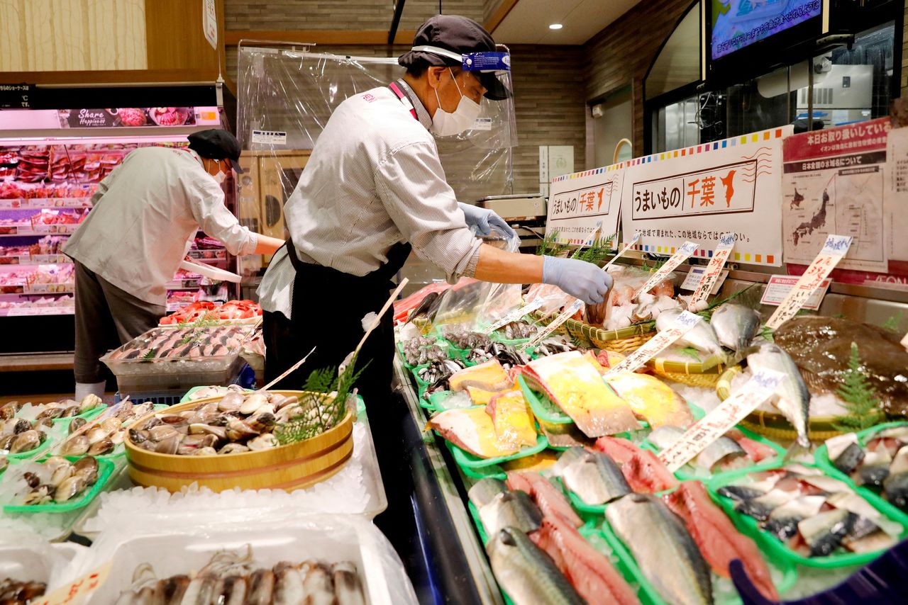FILE PHOTO: A worker wearing a face shield sells fish at a Japanese supermarket, Japan May 28, 2020. REUTERS/Kim Kyung-Hoon//File Photo