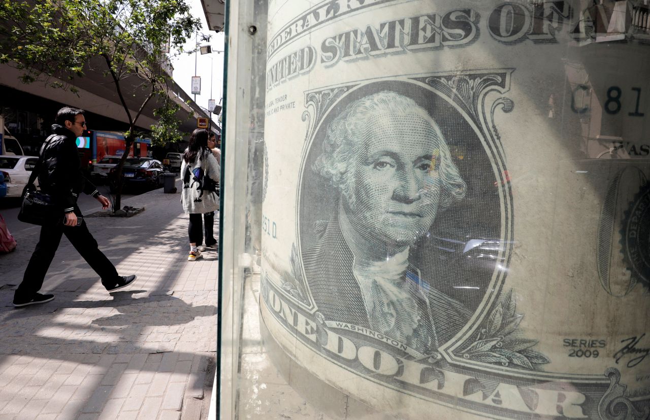 A man walks past a currency exchange point, showing an image of the U.S. dollar in Cairo, Egypt,  March 22, 2022. REUTERS/Mohamed Abd El Ghany